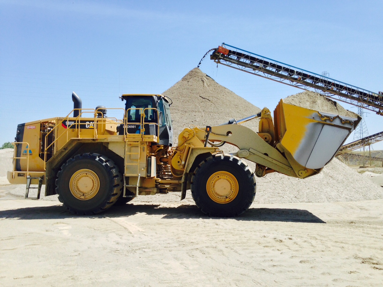 Photo of a loader with pile of aggregate in the background