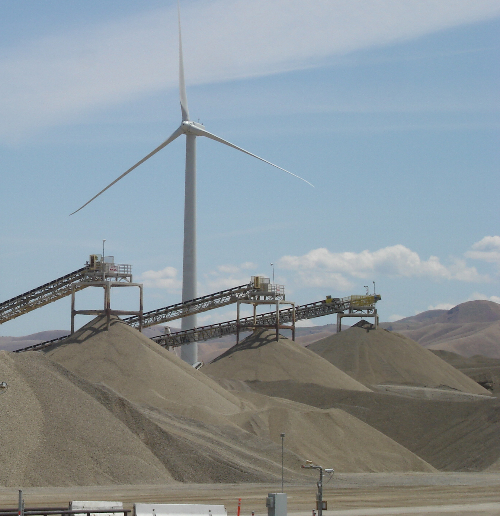 a wide angle shot of a ̳ job site with a windmill in the background