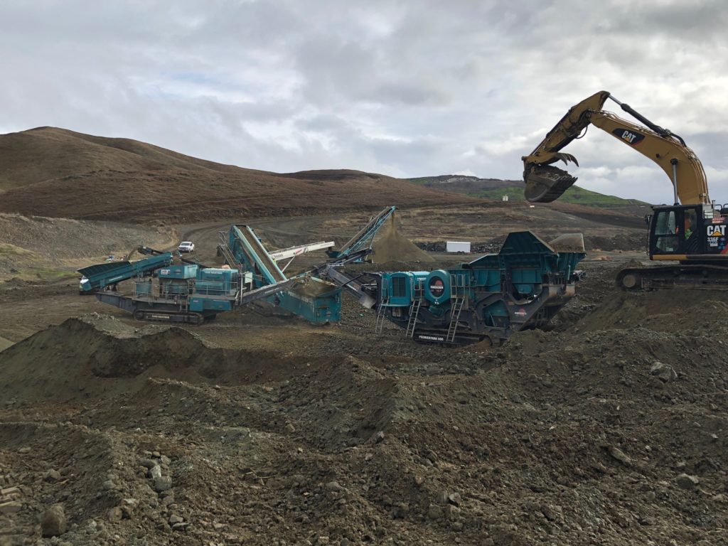 an image of large construction equipment clearing dirt from a landscape